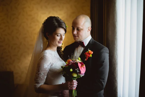 Mariée et marié assis à la fenêtre dans la chambre — Photo