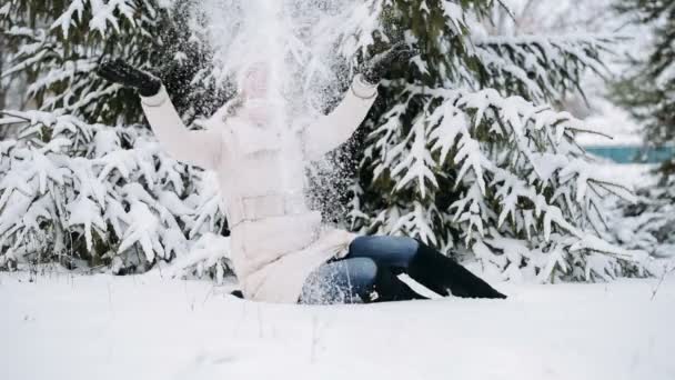 Щаслива молода жінка грає зі снігом — стокове відео