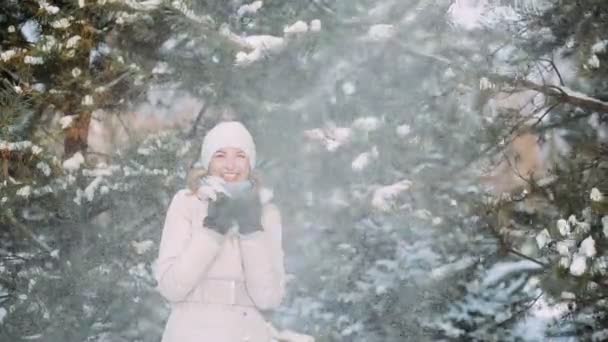 Сніг падає на дівчину з гілками дерев — стокове відео