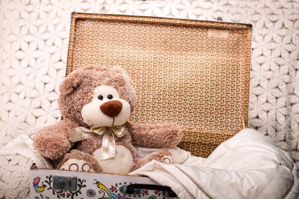nursery with a toy teddy bear in a suitcase