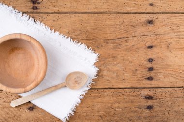 Ahşap kase, kaşık ve rustik ahşap bir masa üzerinde masa örtüsü