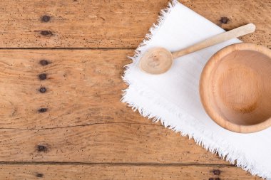 Ahşap kase, kaşık ve rustik ahşap bir masa üzerinde masa örtüsü