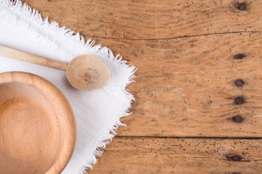 Ahşap kase, kaşık ve rustik ahşap bir masa üzerinde masa örtüsü