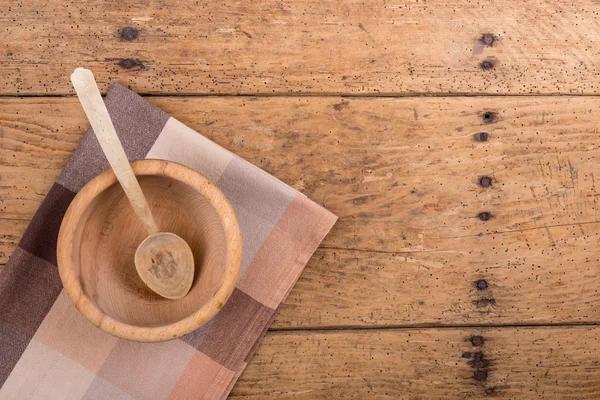 Ahşap kase, kaşık ve rustik ahşap bir masa üzerinde masa örtüsü