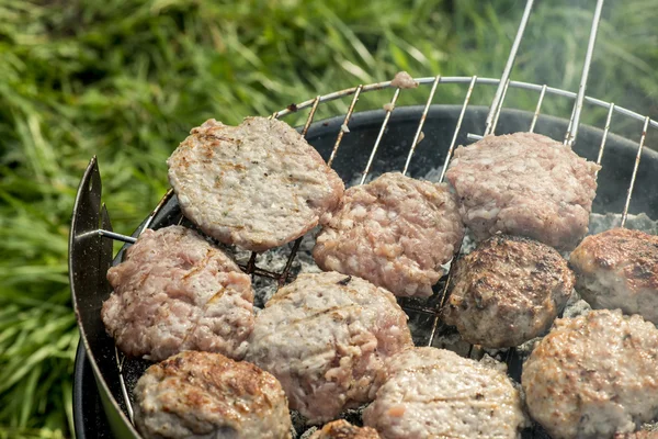 Grillen in der Natur. Hackbällchen auf Holzkohle backen — Stockfoto