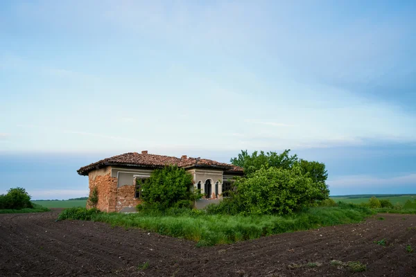 Abandonada velha casa rústica no meio do campo — Fotografia de Stock