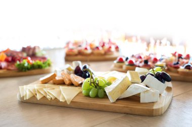 Resepsiyondaki büfe. Tahtadaki kanepelerin çeşitleri. Ziyafet servisi. Yemek, farklı peynir ve et çeşitleriyle aperatifler. Parti Konsepti.