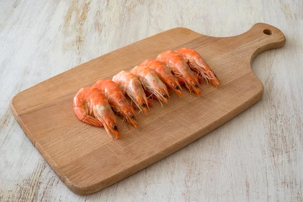 Camarones cocidos dispuestos en una tabla de cocina —  Fotos de Stock