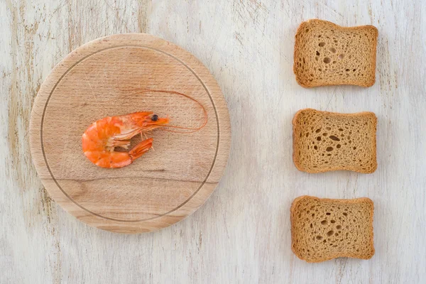 Samenstelling met een garnalen en beschuit op een keukentafel - schrijfruimte — Stockfoto