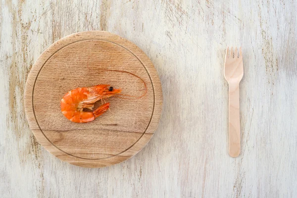 Samenstelling met een garnalen en houten vork op een keukentafel - schrijfruimte — Stockfoto