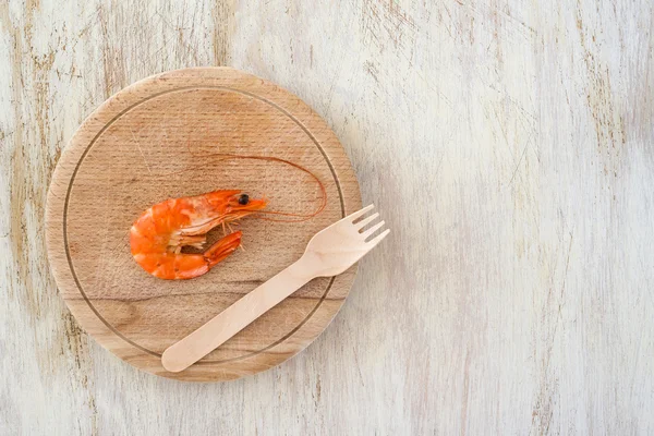 Samenstelling met een garnalen en houten vork op een keukentafel - schrijfruimte — Stockfoto