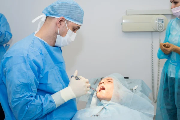 Dentistas durante a cirurgia para colocação de implantes — Fotografia de Stock