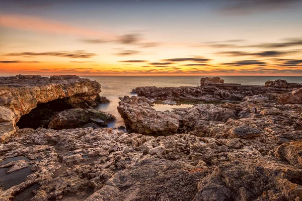 Kayalık sahilde güzel dramatik gündoğumu — Stok fotoğraf