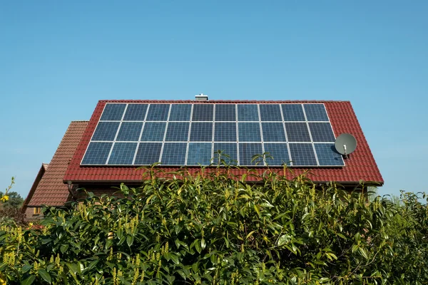 赤い屋根の上の太陽電池パネル — ストック写真