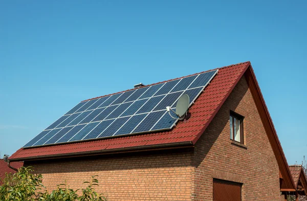 Painel solar em um telhado vermelho — Fotografia de Stock