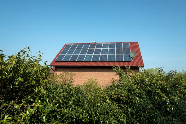 Painel solar em um telhado vermelho — Fotografia de Stock