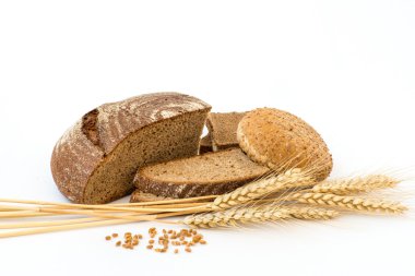 Variety of bread and stalks of wheat isolated on white