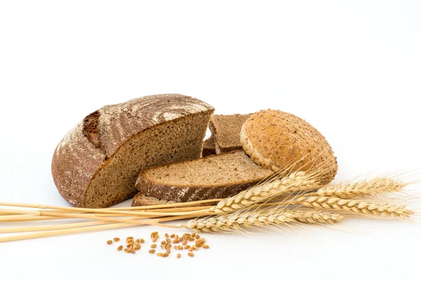 Variety of bread and stalks of wheat isolated on white — Stock Photo, Image