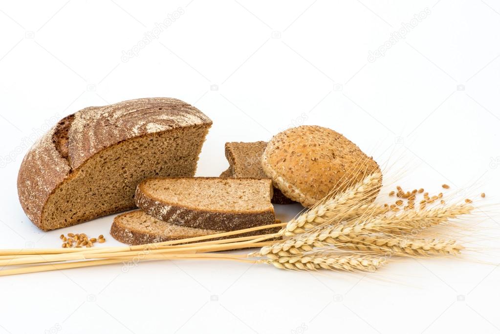 Variety of bread and stalks of wheat isolated on white