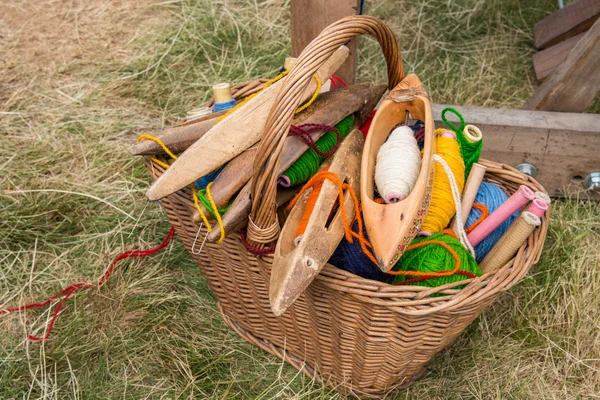 Weaving shuttles and  multi-colored yarn in a basket — Stock Photo, Image