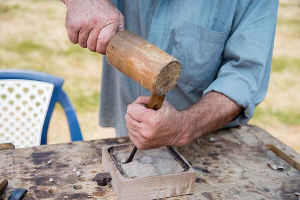 Old woodcarver working with mallet and chiesel, vintage style