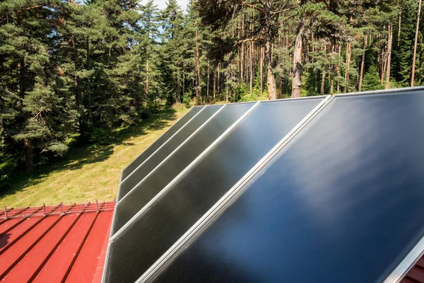 赤い屋根の上の太陽電池パネル — ストック写真