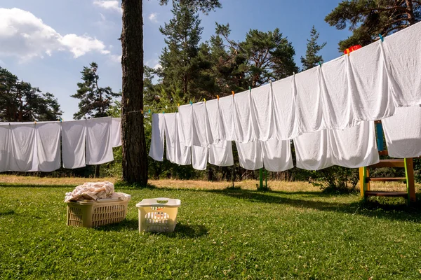 Frische saubere weiße Handtücher trocknen auf der Waschleine im Freien — Stockfoto