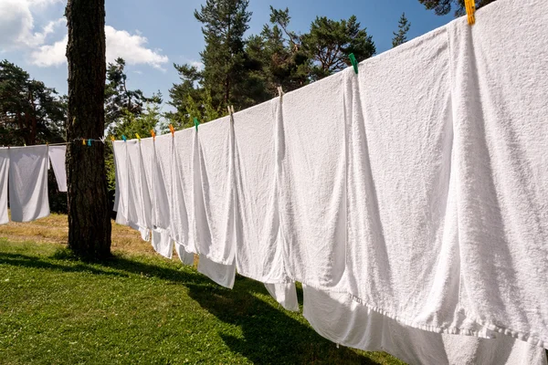 Frische saubere weiße Handtücher trocknen auf der Waschleine im Freien — Stockfoto