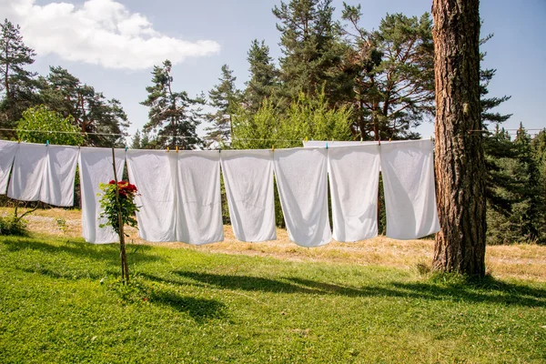 Frische saubere weiße Handtücher trocknen auf der Waschleine im Freien — Stockfoto