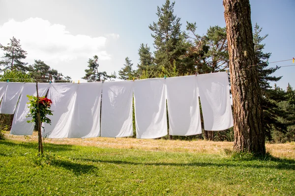 Frische saubere weiße Handtücher trocknen auf der Waschleine im Freien — Stockfoto