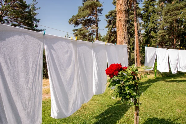 Frische saubere weiße Handtücher trocknen auf der Waschleine im Freien — Stockfoto