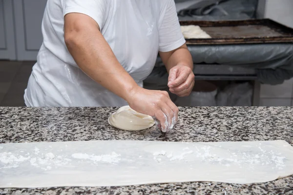 Primer plano de manos femeninas amasando masa y haciendo banitsa — Foto de Stock