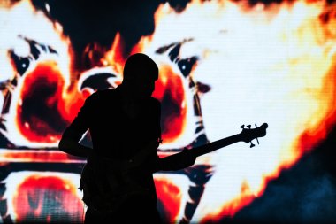 silueti bir sahne alanı'nda bir gitarist