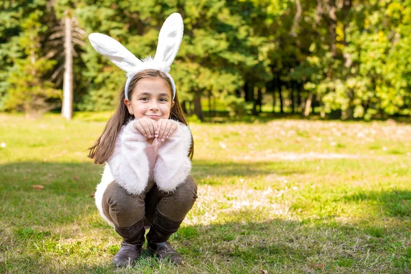 Adorable little girl outdoors at beautiful autumn day with rabbit ears on her head — Stock Photo, Image
