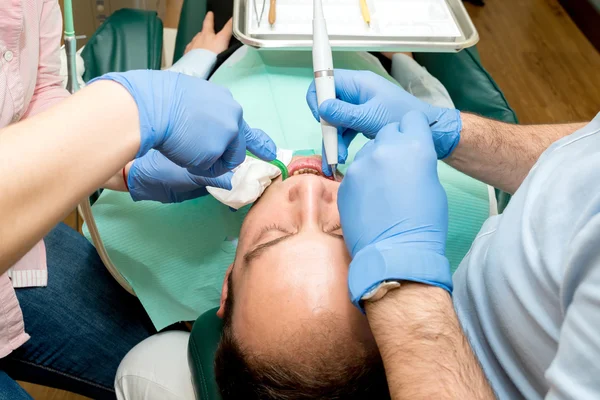 Οδοντίατρος που κάνει οδοντιατρική θεραπεία σε ασθενή — Φωτογραφία Αρχείου
