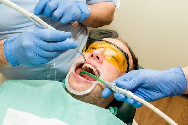 Tandarts doet een tandheelkundige behandeling op een patiënt — Stockfoto