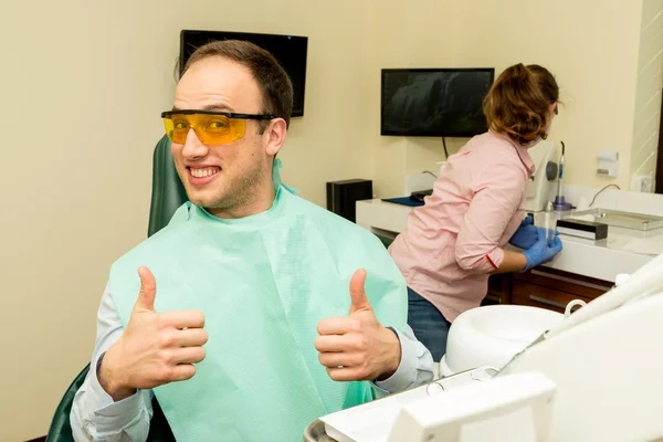 Dentista haciendo un tratamiento dental en un paciente — Foto de Stock