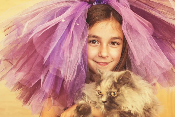 Fille habillée en violet tenant le chat dans ses mains — Photo
