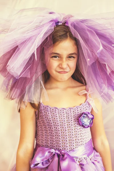 Chica vestida de púrpura con un sombrero divertido — Foto de Stock