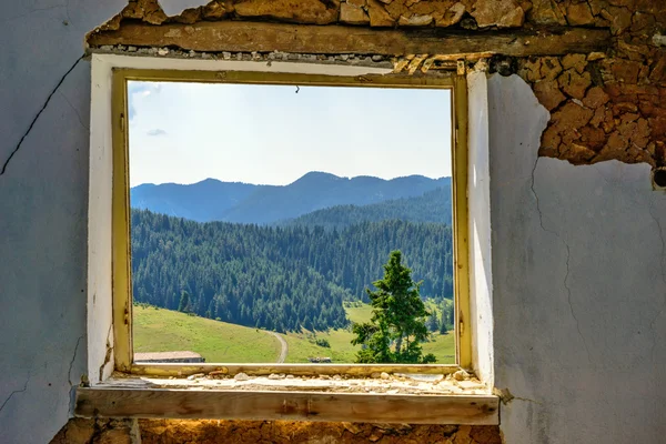Paisagem montanhosa através da janela de uma casa abandonada — Fotografia de Stock