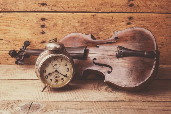 Antieke clock en oude viool over vintage houten tafel — Stockfoto