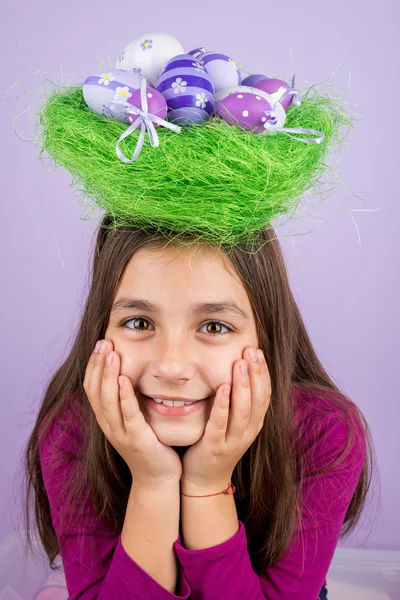 Bambina e nido con uova di Pasqua sopra la testa — Foto Stock