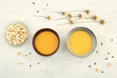 Balkabağı kremalı çorba ve kızarmış ekmek, en iyi manzara. Sonbahar ya da kış balkabağı çorbası masada kurumuş çiçeklerle.