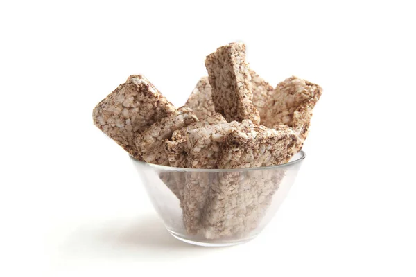 Puffed buckwheat cakes in glass bowl isolated on white background. Wholegrain crispbreads, cereal dietary crackers.