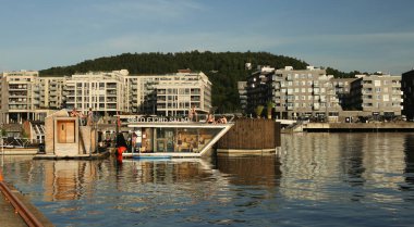 Oslo, Norveç - 9 Temmuz 2021: Fiyortta yüzen Oslo saunası, Opera binası ile Sorenga iskelesi arasında. Şehir merkezindeki Oslo 'da sauna teknesi.. 