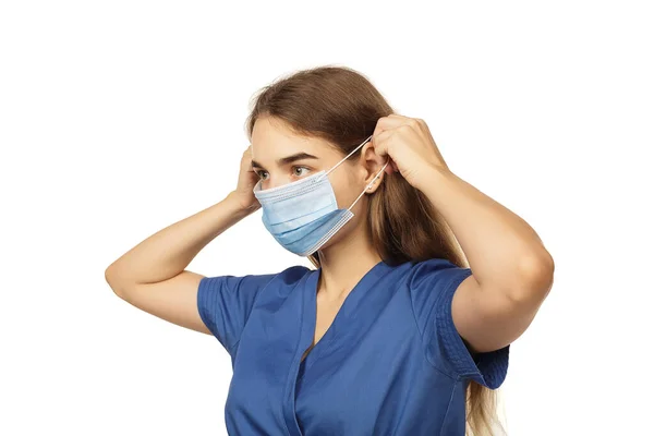 白い背景に隔離された保護使い捨てフェイスマスクを身に着けている美しい若い女性医師の外科医 ウイルス対策の概念 コロナウイルスの現代的なウイルスの脅威 — ストック写真