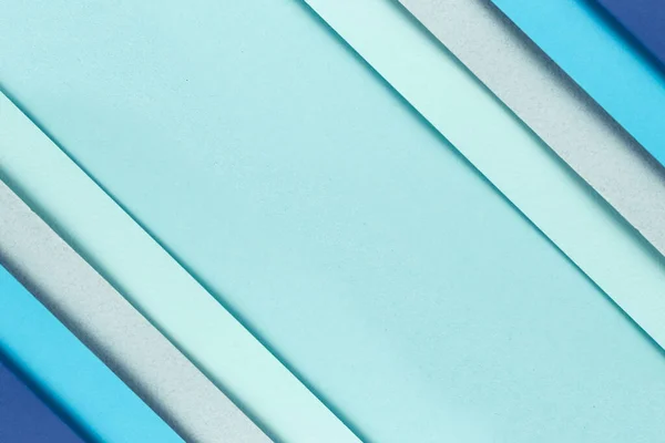 Material design blue background. Craft paper sheets are folded in different ways. A photo