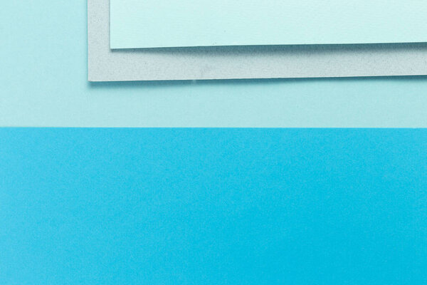 Материал дизайн синий фон. Ремесленные листы бумаги складываются по-разному. Фото.