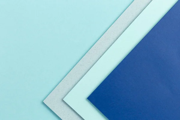 Material design blue background. Craft paper sheets are folded in different ways. A photo