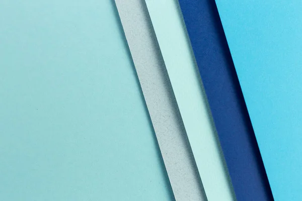 Material design blue background. Craft paper sheets are folded in different ways. A photo